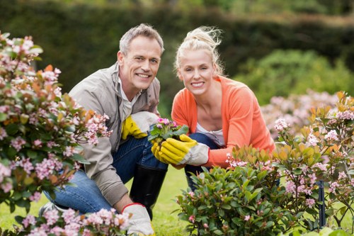 Professional gardeners following safety procedures during garden work